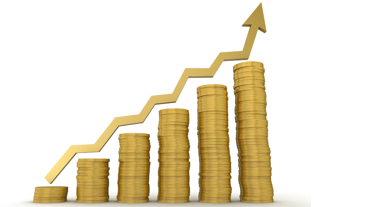Stacks of gold coins with market value arrow going up.